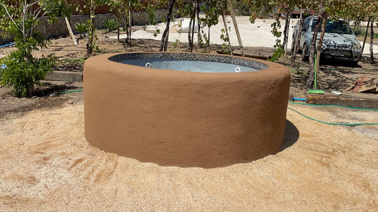 Jacuzzi circular a medida con exterior texturado y mosaico interior